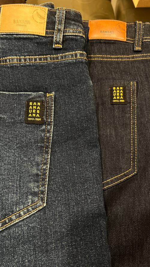 Duas calças jeans lado a lado: à esquerda lavada com ozônio, mais clara e com desgaste; à direita a mesma base crua, azul escuro